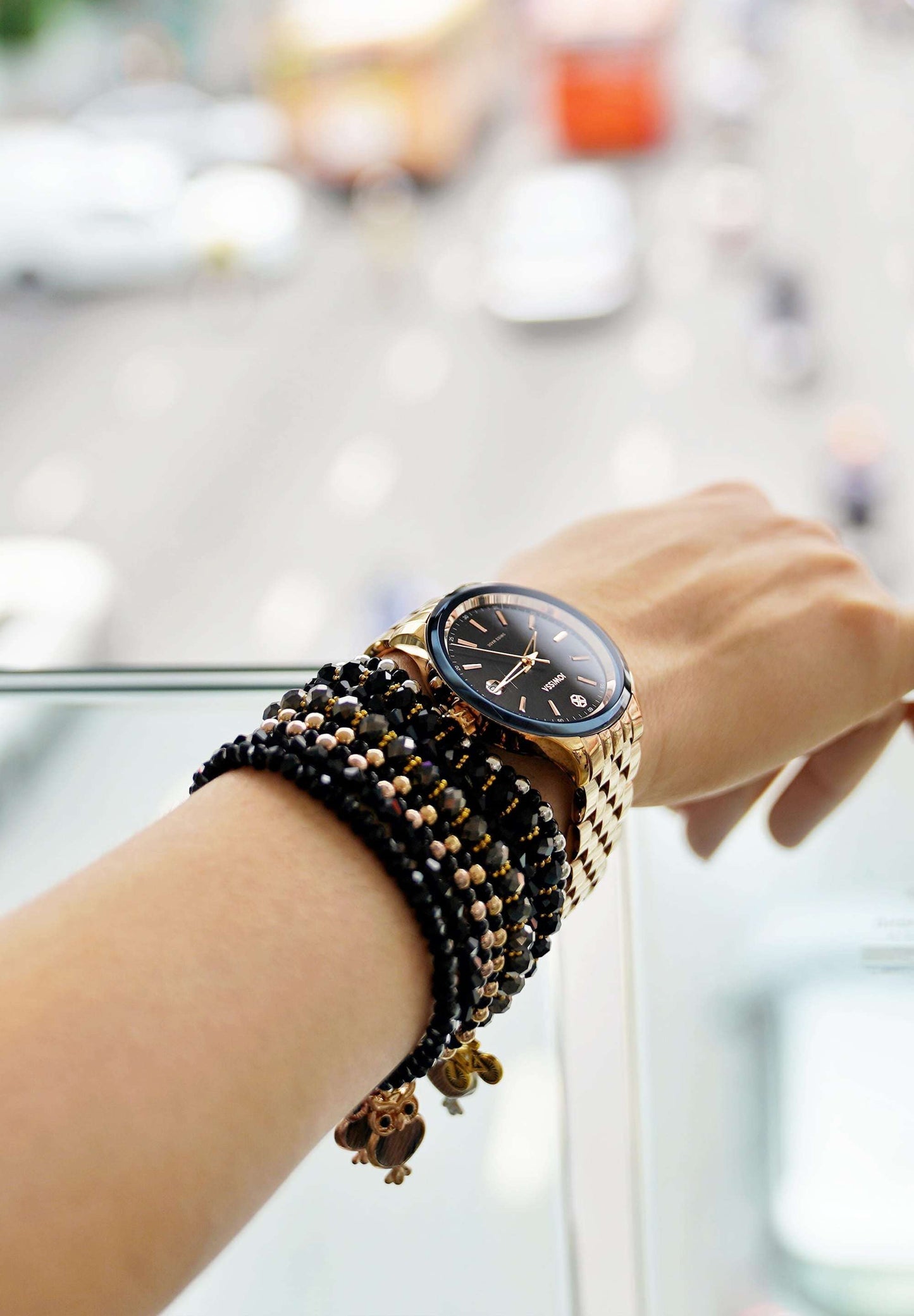 J4.234.M unisex watch - worn by a woman with a hand full of bracelets - has a black sunray dial protected by robust tempered mineral glass. The watch has a precise Ronda Swiss quartz movement - all swiss made - size medium