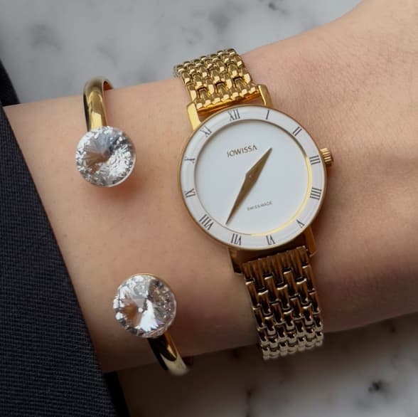 Woman wearing a gold Jowissa Roma Swiss Made watch with a white dial and matching jewelry