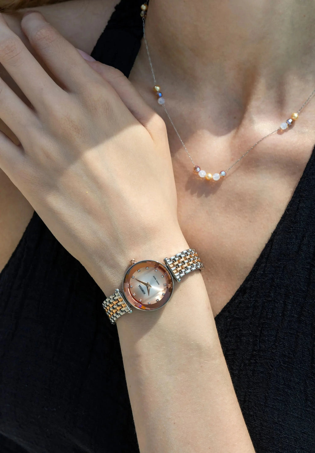 Elegant swiss ladies watch, 27mm diameter, facetted glas, degradee dial from silver to rose, bicolor braceelet and 12 rhinestones. All Swiss Made.