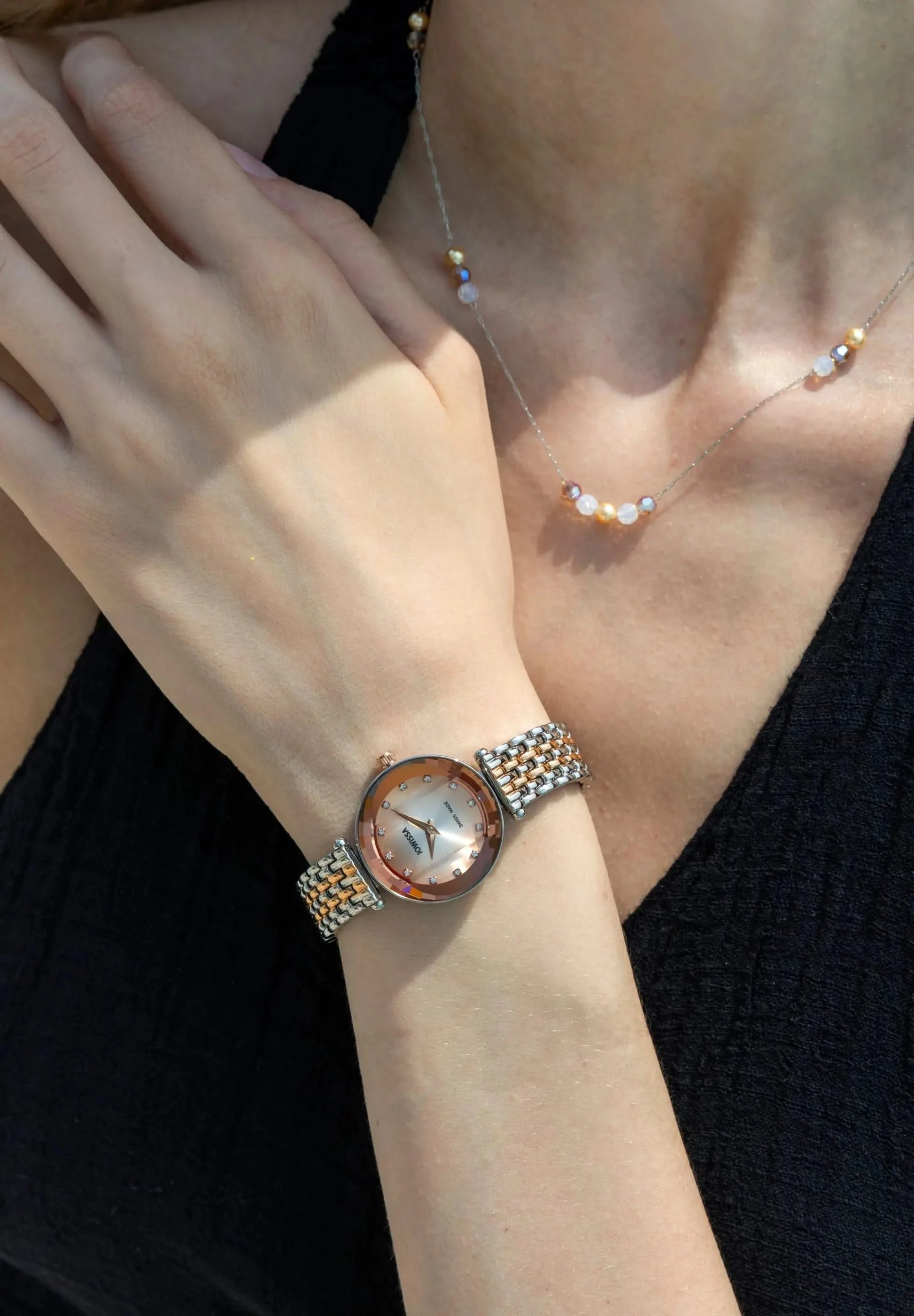 Elegant swiss ladies watch, 27mm diameter, facetted glas, degradee dial from silver to rose, bicolor braceelet and 12 rhinestones. All Swiss Made.