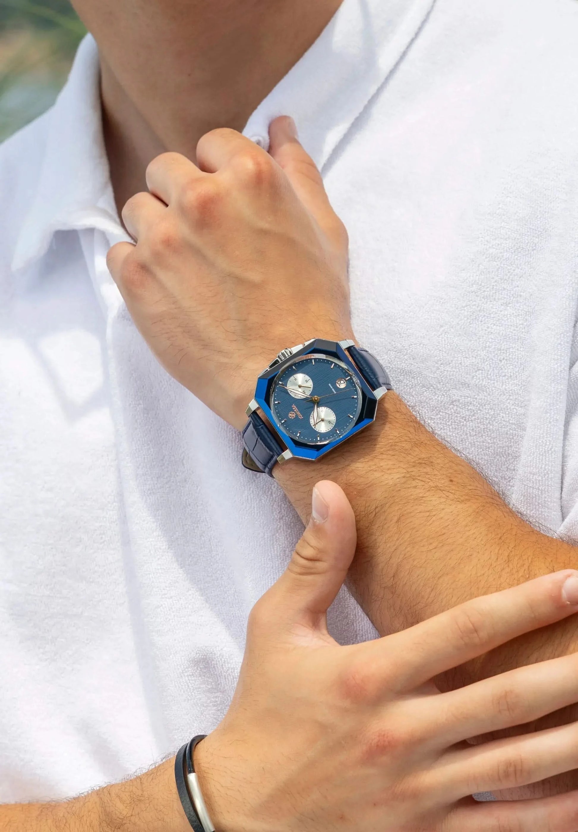 A man is wearing a Swiss Made Jowissa watch. This blue Octa 6 Chronograph has a facetted glas and a blue leather strap. 