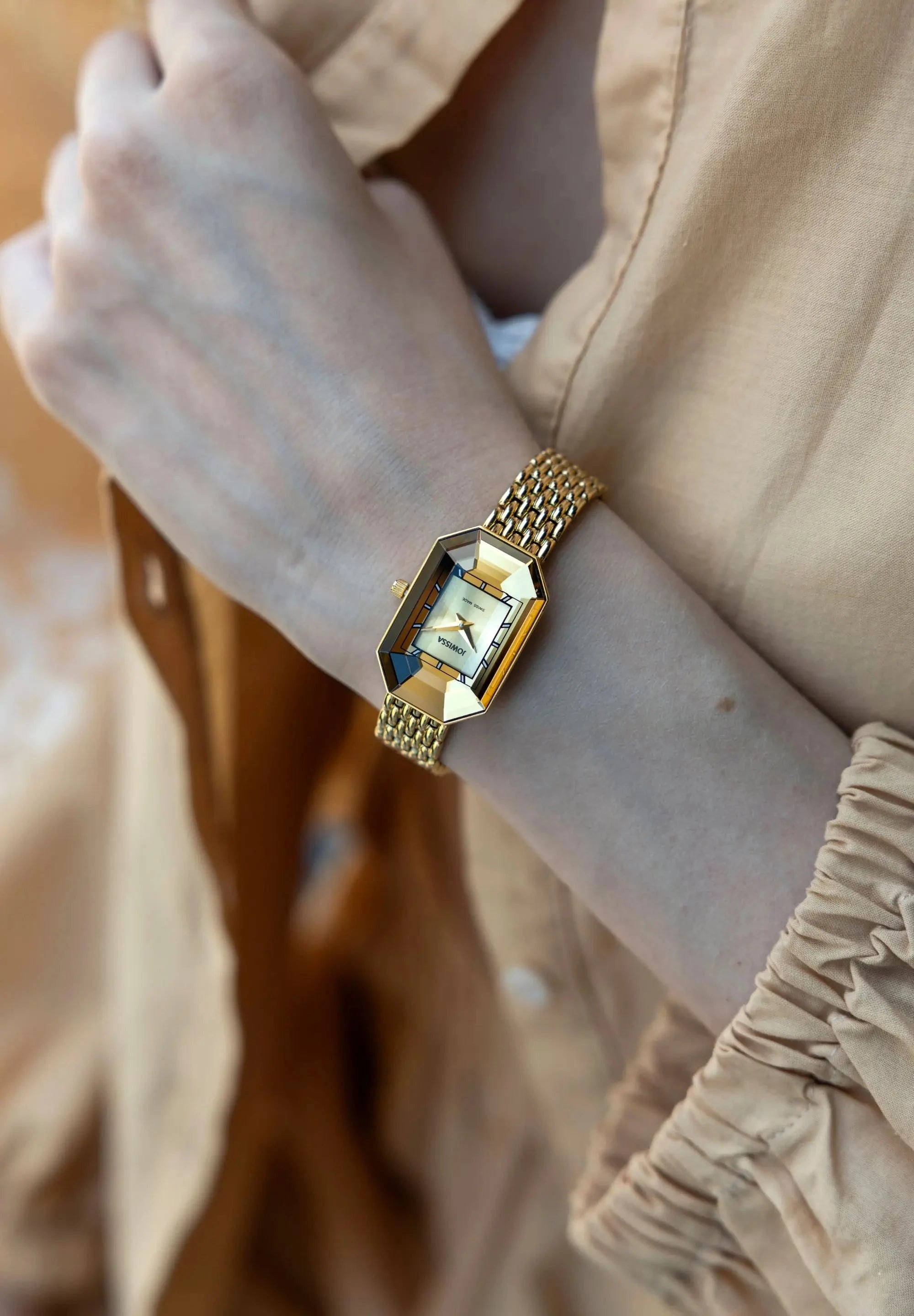 Spectacular golden Facet Emerald on a womans wrist. Its octangular case and fine Milanese bracelet made of stainless steel shine bright and the facetted glas ads extra sparkle.  All Swiss Made.