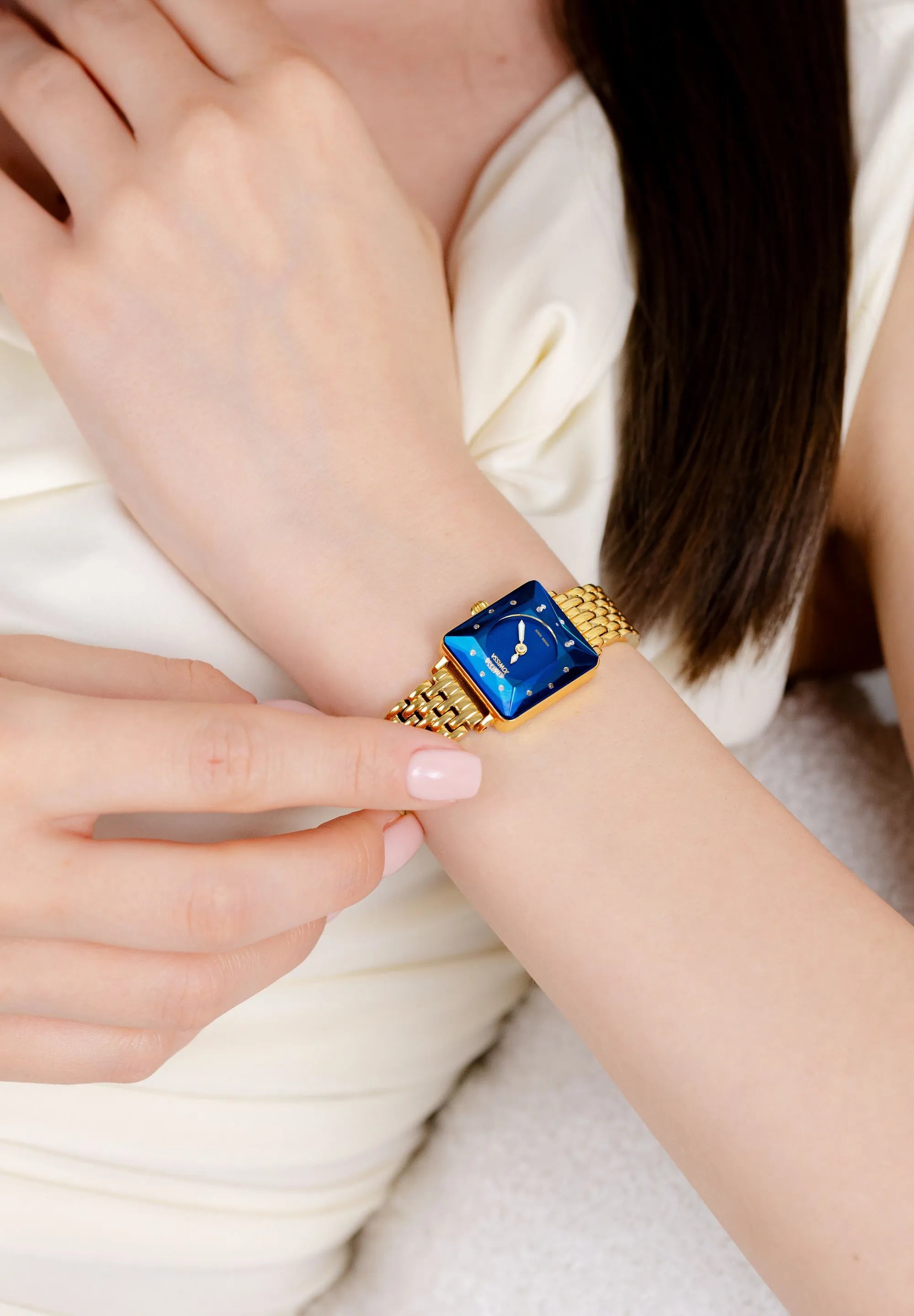 Petite square watch for women with a golden bracelet and a deep blue dial. Swiss Made.