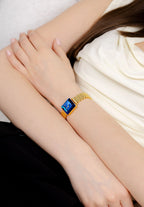 Trendy timepiece for women, small, all golden with a blue dial and square watch case shape. Swiss Made.