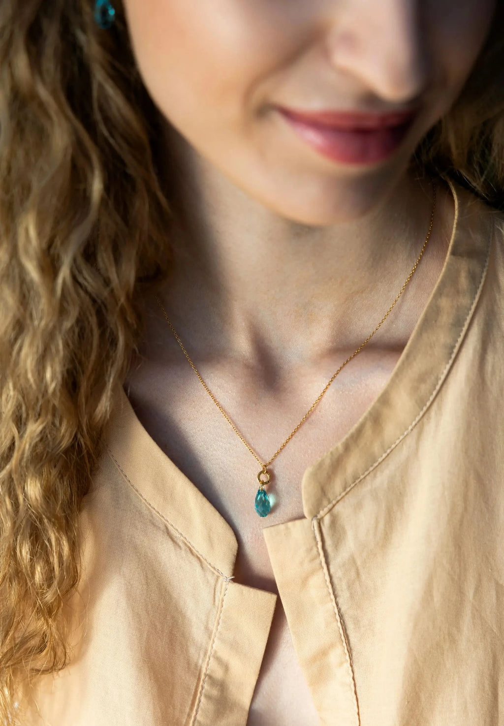 Stainless steel necklace in gold with a big 20mm Austrian crystal in turquoise, completing each outfit.