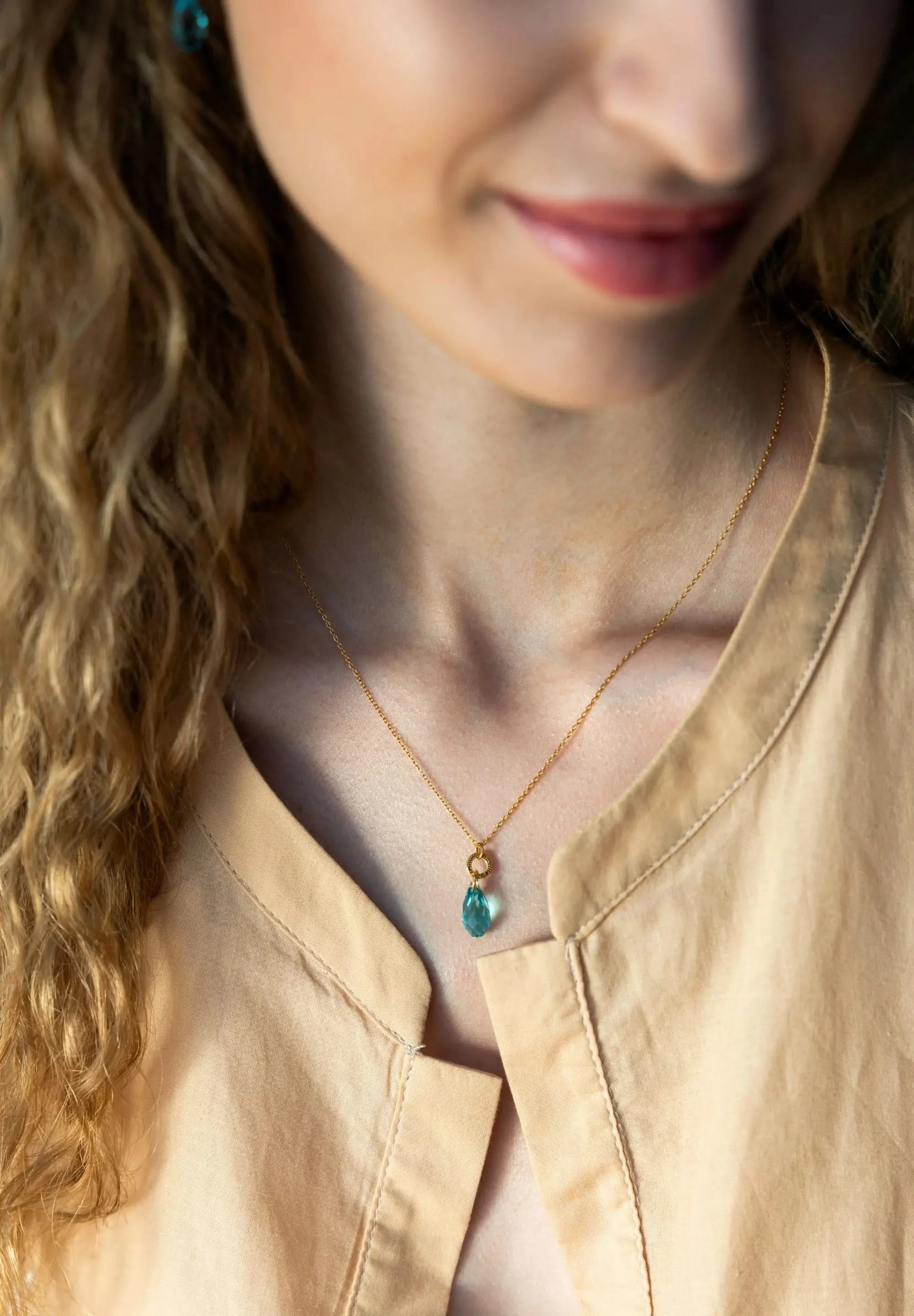 Stainless steel necklace in gold with a big 20mm Austrian crystal in turquoise, completing each outfit.