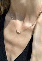This necklace showcases a luminous clear/gold Austrian crystal, elegantly threaded onto a fine stainless steel chain.