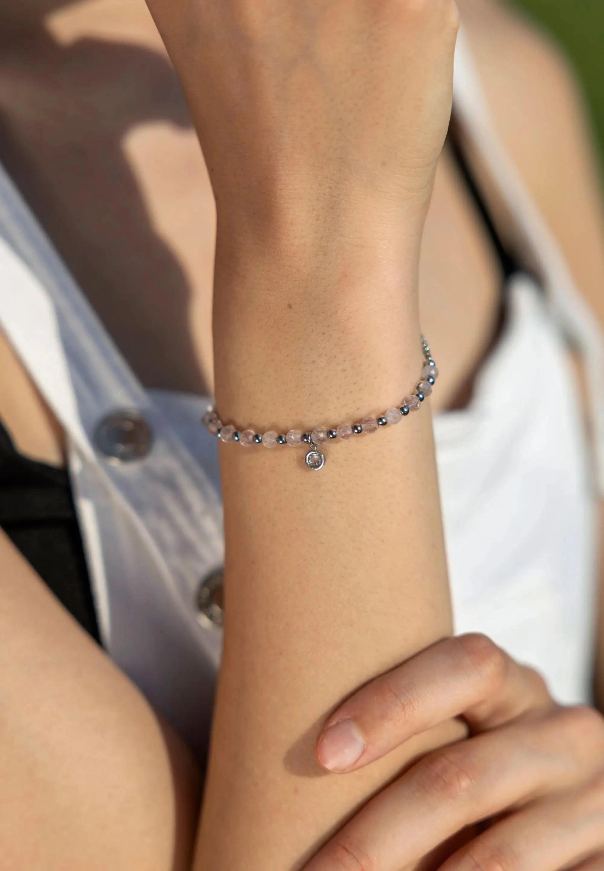 A woman is wearing a beautiful bracelet in silver and rose with Rose quartz on her wrist from the brand Jowissa