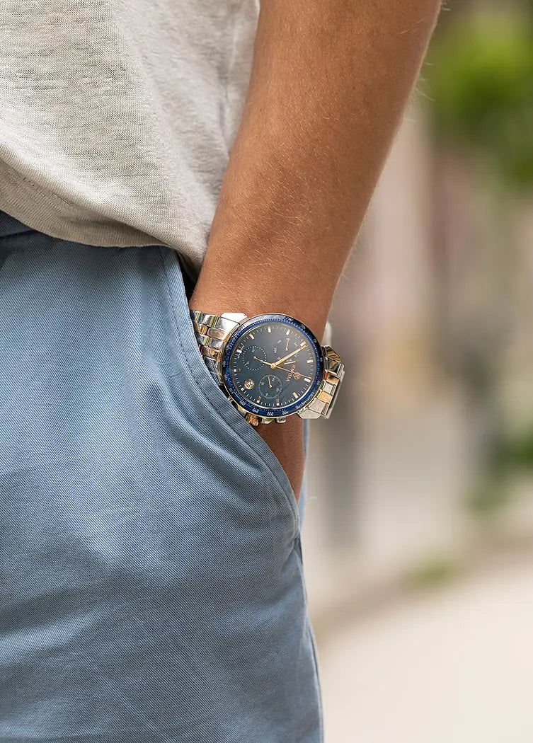 Person wearing a Swiss Made Jowissa Chronograph watch with a blue face and rose gold silver case, standing outdoors. The bracelet is a 22mm stainless steel band.
