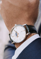 Black swiss watch for men - the swiss watch has a black leather strap and a white dial with the moon and stars on it - has gold details in the front