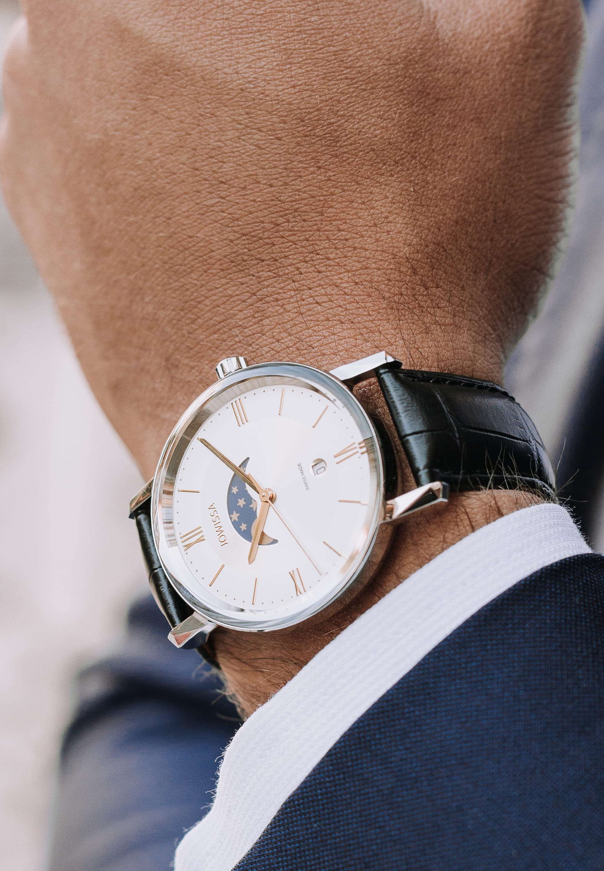 Black swiss watch for men - the swiss watch has a black leather strap and a white dial with the moon and stars on it - has gold details in the front