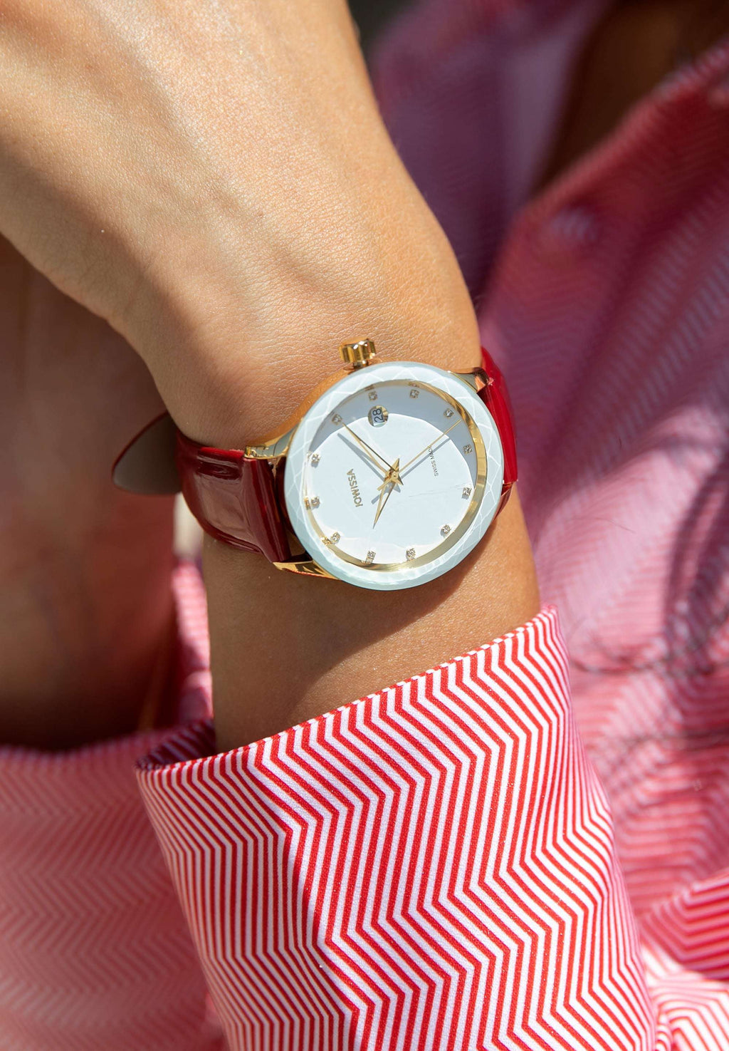 J6.233.M Swiss Watch –  exquisite women’s timepiece has a gold stainless steel case with a  white sunray dial, adorned with 12 applied rhinestone hour markers for a touch of glamour. The triangular, hollow Dauphine-style hands and diamond-cut bezel bring sophistication to its design. The genuine patent leather strap in red enhances the bold style - all swiss made