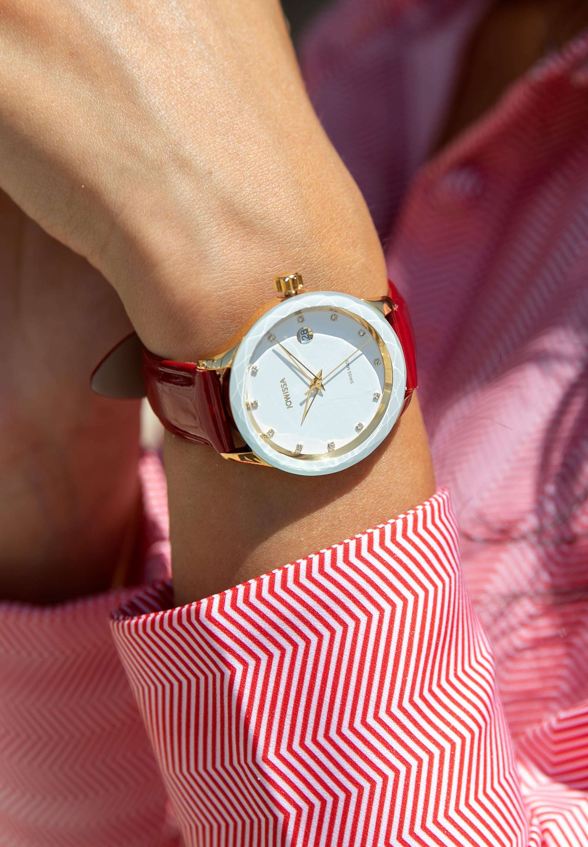 J6.233.M Swiss Watch –  exquisite women’s timepiece has a gold stainless steel case with a  white sunray dial, adorned with 12 applied rhinestone hour markers for a touch of glamour. The triangular, hollow Dauphine-style hands and diamond-cut bezel bring sophistication to its design. The genuine patent leather strap in red enhances the bold style - all swiss made
