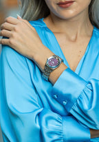 A attractive red dial swiss ladies watch with a stainless steel strap perfectly matched with a light blue dress.