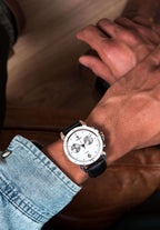 Black swiss made watch for men - worn by a man who has a jacket jeans and a swiss watch with white dial - all swiss made