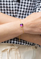 Goldfarbenes Edelstahl-Schmuckarmband mit violettem Stein für Damen.