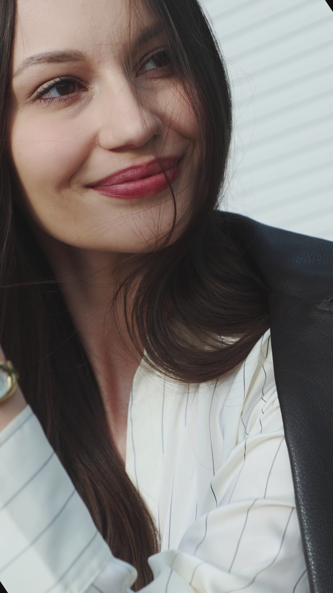 Swiss gold watch for women - with gold strap and white dial - worn by a girl with red lipstick and white shirt